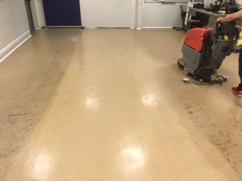 Operario limpiando un suelo industrial mediante una limpieza técnica