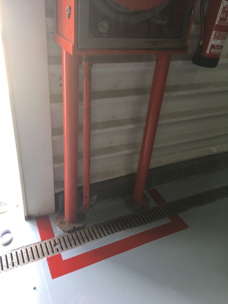 Señalización de una zona con un equipamiento de seguridad en una nave industrial